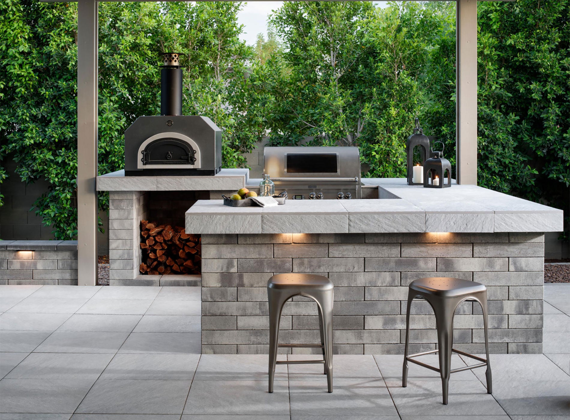 An outdoor kitchen with a pizza oven and bar counter